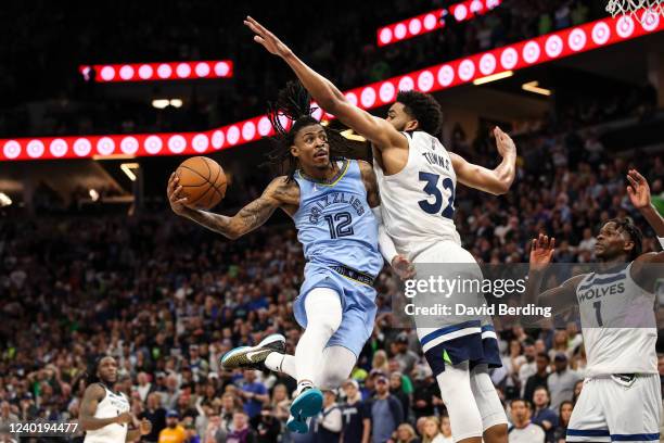 Ja Morant of the Memphis Grizzlies goes up for a shot while Karl-Anthony Towns of the Minnesota Timberwolves defends in the fourth quarter of the...