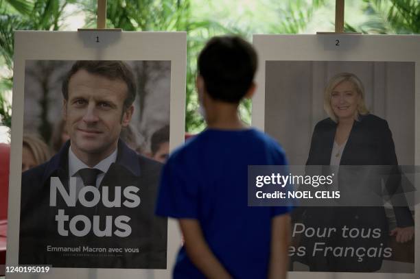 Pictures of candidates Emmanuel Macron and Marine Le Pen are displayed during the second round of voting in the French presidential elections at the...