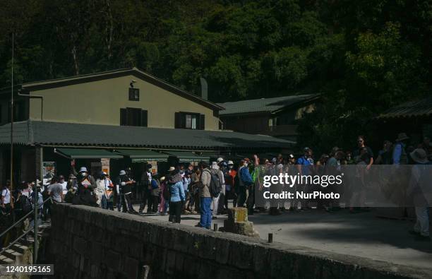 Line of tourists at the entrance to the ancient Inca city of Machu Picchu located in the Andes at an altitude of 2,430 meters . The most famous icon...