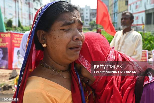 Relatives of victims killed in the Rana Plaza building collapse react while marking the ninth anniversary of the disaster at the site where the...
