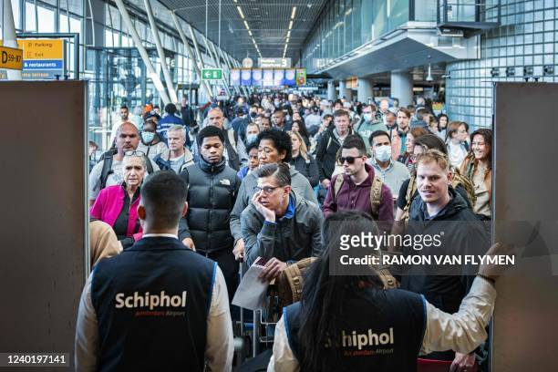Travellers wait in a departure hall at Schiphol airport, near Amsterdam, a day after a wild strike by KLM luggage handlers which caused many flights...