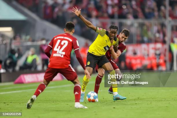 Jamal Musiala of Bayern Muenchen, Jamie Bynoe-Gittens of Borussia Dortmund and Benjamin Pavard of Bayern Muenchen battle for the ball during the...