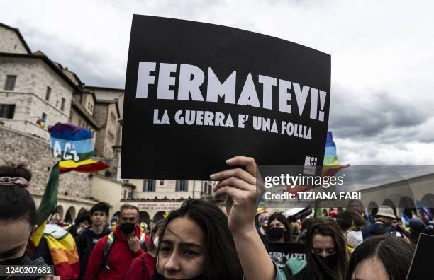 Woman holds up a sign reading during the "March for Peace" from Perugia to Assisi on April 24, 2022 in Assisi.