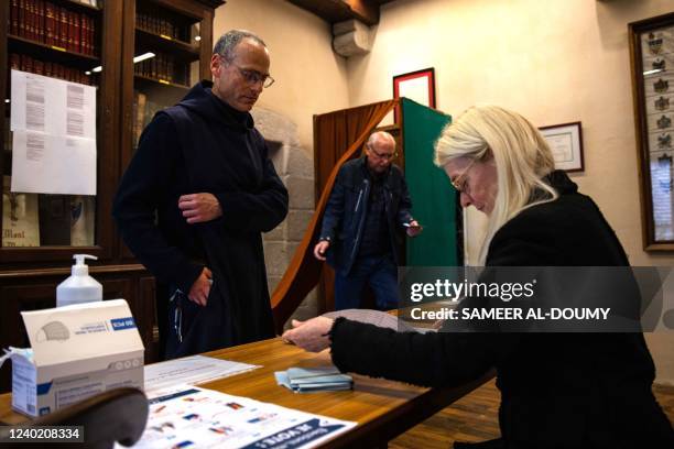 Monk of the Monastic of the Fraternities of Jerusalem prepares to cast his ballot at a polling station in Le Mont-Saint-Michel, northwestern France,...