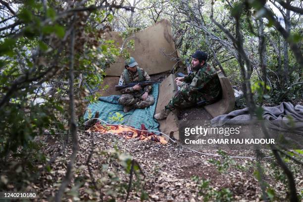 Fighters affiliated to the Hayat Tahrir al-Sham jihadist group take a position in the mountainous northern countryside of Syria's northwestern...