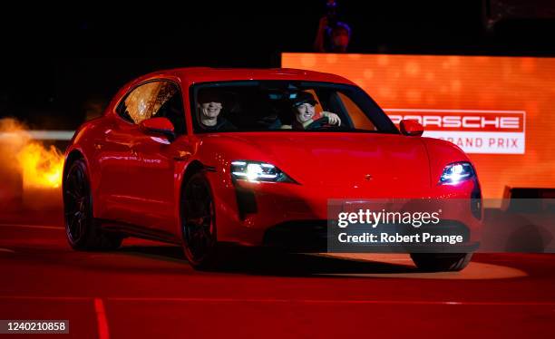 Iga Swiatek of Poland drives the Porsche Taycan GTS winners car with Porsche CEO Oliver Blume in the drivers seat after defeating Aryna Sabalenka of...