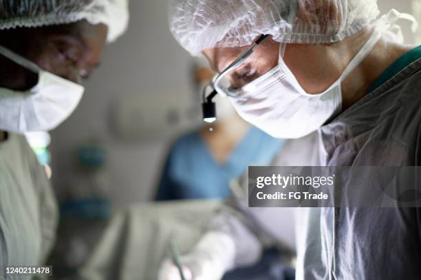 médicos haciendo una cirugía en quirófano en el hospital - transplant surgery fotografías e imágenes de stock