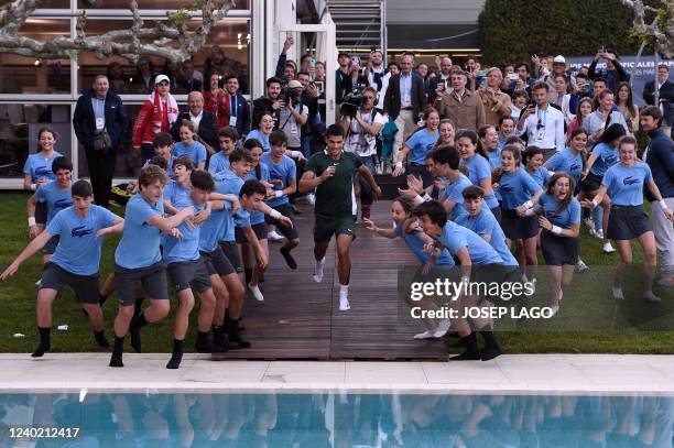 Spain's Carlos Alcaraz runs to dive into the pool after winning against Spain's Pablo Carreno-Busta during the ATP Barcelona Open tennis tournament...