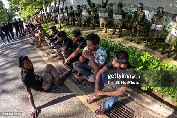 Sri Lankan university students take rest after protesting in front of the prime minister, Mahinda Rajapaksa's residence as STF police stand guard at...