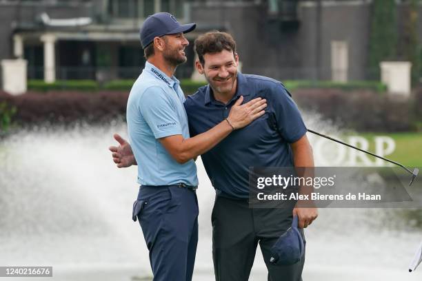 Former tennis player Mardy Fish and former NFL player Tony Romo hug after completing the 18th hole to force a playoff in final round of the ClubCorp...