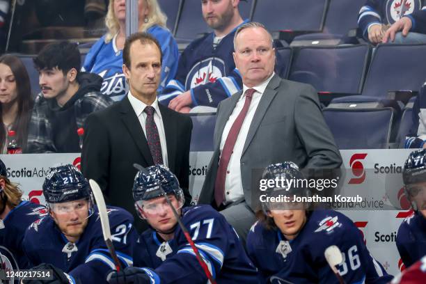 Assistant Coach Jamie Kompon and Interim Head Coach Dave Lowry of the Winnipeg Jets look on from the bench during first period action against the...