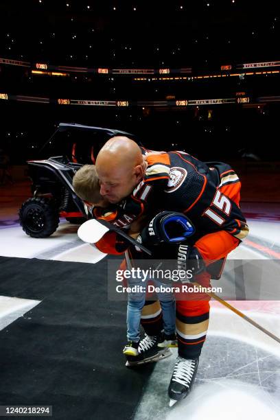 Ryan Getzlaf of the Anaheim Ducks hugs his son during his retirement ceremony prior to his last career NHL game before the game between the St. Louis...