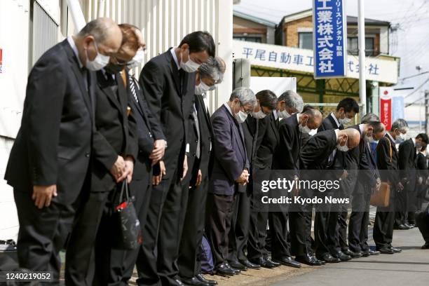 People observe a moment of silence near the site of the 2005 fatal train derailment in the western Japan city of Amagasaki on April 25 its 17th...