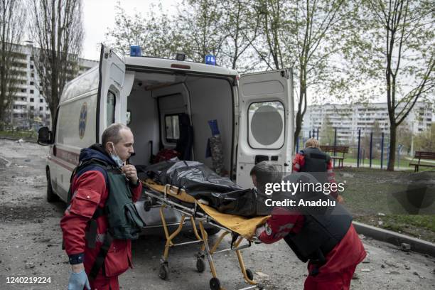 Paramedics carry the body of a resident to an ambulance as it was recovered from under the rubble in the Saltivka neighborhood in Kharkiv, Ukraine,...