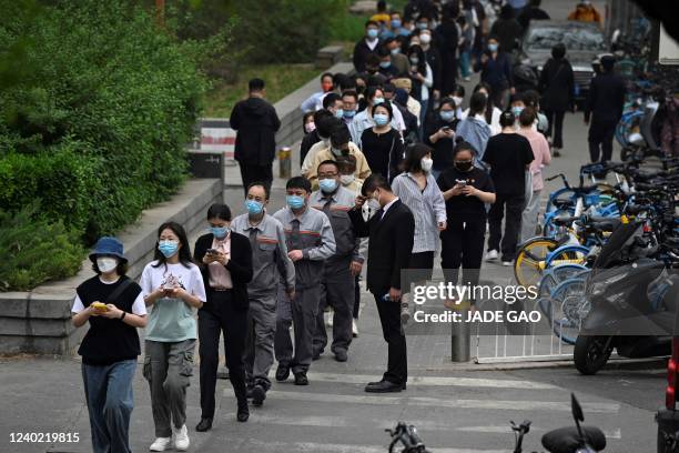 People wait in line to be tested for the Covid-19 coronavirus at a swab collection site in Beijing on April 25, 2022. - Fears of a hard Covid...