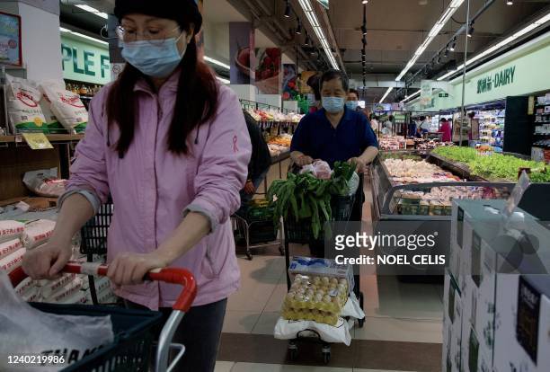 People buy food and household provisions at a supermarket in Beijing on April 25, 2022. - Fears of a hard Covid lockdown sparked panic buying in...