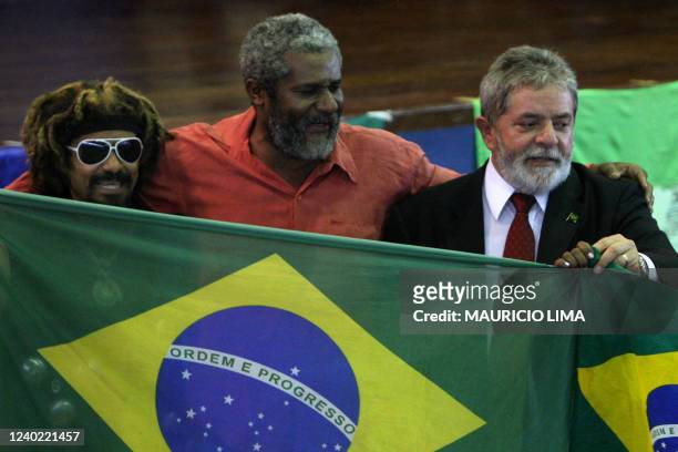 Brazilian President Luiz Inacio Lula da Silva holds a Brazilian flag while meeting to celebrate Christmas season with homeless people and recycling...