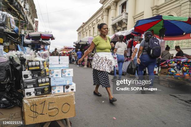 Woman walks next to a stand selling protective masks at a local market in downtown San Salvador. On April 21, the Salvadoran Ministry of Health...