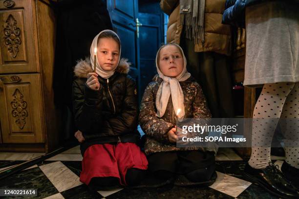 Two little kneeling girls held lit candles in their hands during the celebration at the Moldavian Orthodox Church. The armed conflict in Ukraine has...