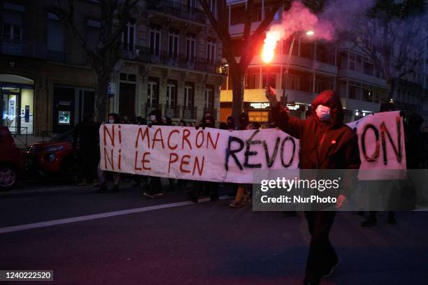 Man holds a flare in front of a banner reading 'Nor Macron Nor Le Pen Revolution'. Counting the ballot papers in a Toulouse's polling station. The...