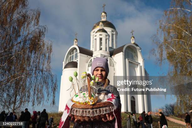 Girl holds an Easter basket with a paska outside the Church of Saint Andrew the First-Called Apostle during the Orthodox Easter celebration in Bucha...