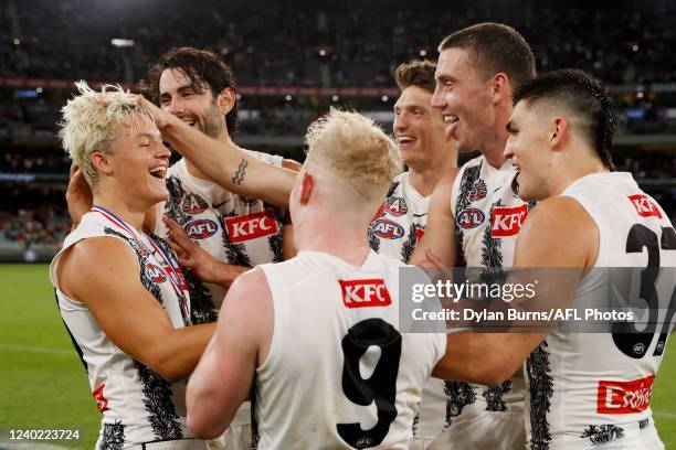 Jack Ginnivan of the Magpies celebrates withe teammates after winning the Anzac Day medal during the 2022 AFL Round 06 match between the Essendon...