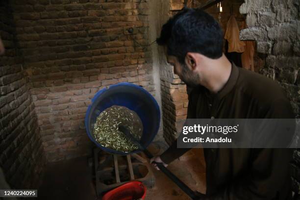 Pakistani man carries a bucket of bullets at a gun shop in Darra Adam Khel village, in Peshawar, Pakistan on April 20, 2022. The Pakistani city of...