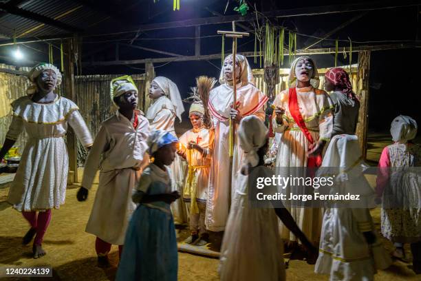 White-faced Bwiti believers chanting and dancing during an initiation ceremony. In bwiti ceremonies, participants cover their faces with a white...