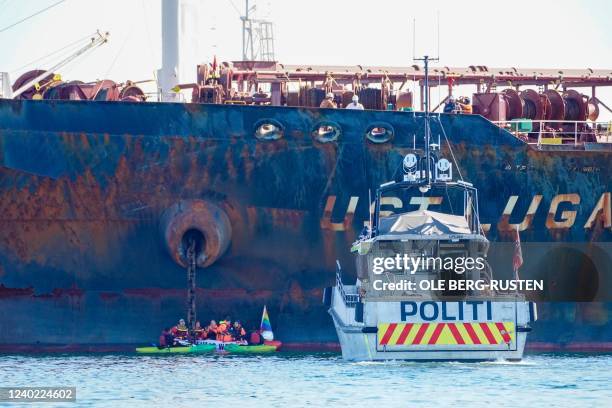 Police vessel parks near Greenpeace environmental activists as they stage a action against the ship Ust Luga, which will reportedly unload Russian...