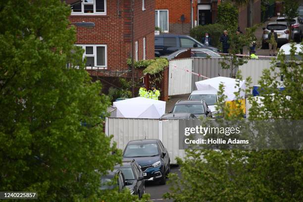 Police and forensic officers, along with police tents, are seen outside a home where three women and a man were found stabbed to death on April 25,...