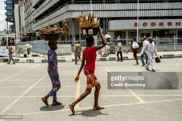 Informal street vendors carry goods on their heads in Lagos, Nigeria, on Friday, April 22, 2022. Choked supply chains, partly due to Russias invasion...