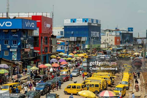 Yellow taxi vans on the roadside opposite stores in the Ikeja district of Lagos, Nigeria, on Friday, April 22, 2022. Choked supply chains, partly due...