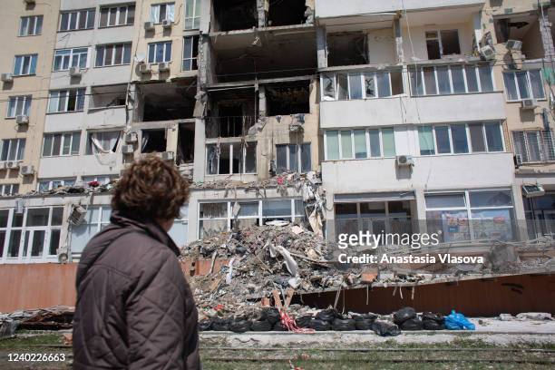 Resident whose apartment got destroyed as a result of a missile strike on a residential building, looks at the work of the rescue team on April 25,...