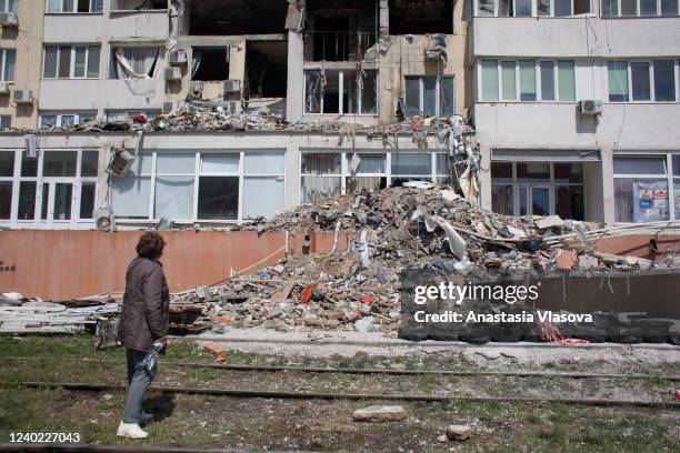 Resident whose apartment got destroyed as a result of a missile strike on a residential building, looks at the work of the rescue team on April 25,...