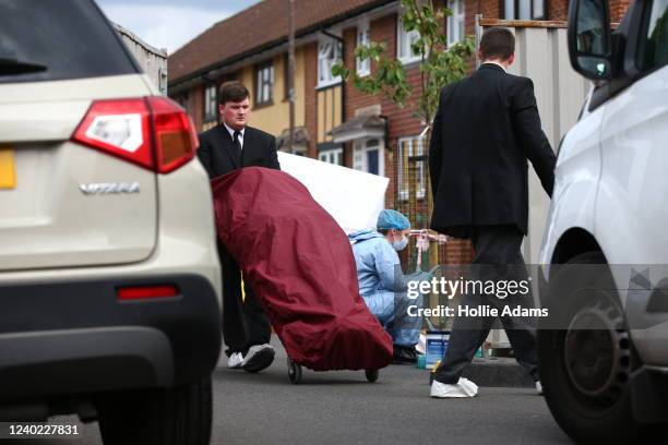 Bodies are removed and collected by a private ambulance from the scene where three women and a man were found stabbed to death on April 25, 2022 in...