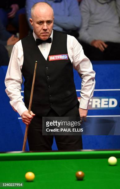 Scotland's John Higgins prepares to play a shot against Thailand's Noppon Saengkham during their World Championship Snooker second round match at The...