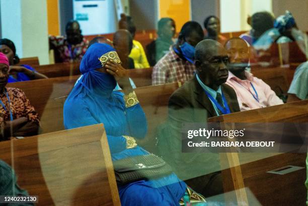 Woman holds her head while attending the opening of a long-awaited trial in the Special Criminal Court, set up to prosecute suspected war criminals,...