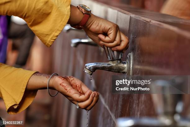 Girl washes her hands on a hot summer day in the premises of Jama Masjid in Old Delhi India on 25 April 2022