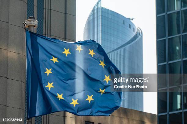 Flag of Europe on flagpole waving in the blue sky on a sunny day among the high buildings in the European capital city Brussels near Brussels North...