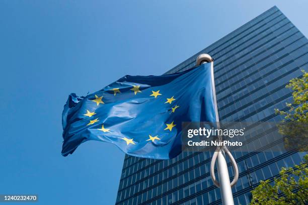 Flag of Europe on flagpole waving in the blue sky on a sunny day among the high buildings in the European capital city Brussels near Brussels North...