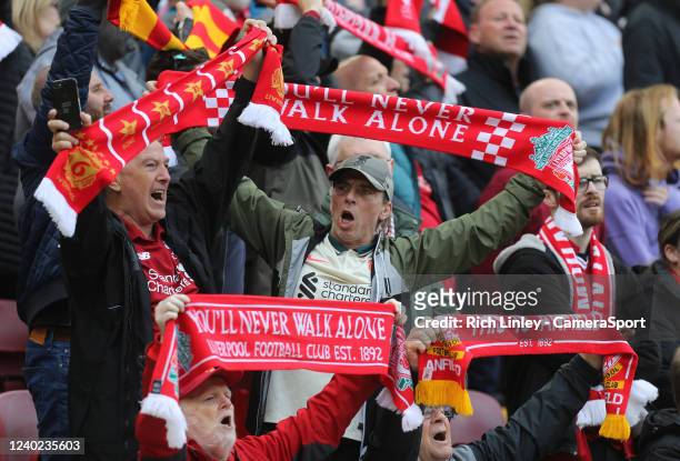 Liverpool fans hold scarves aloft as they sing their 'You'll never walk alone' anthem ahead of kick-off during the Premier League match between...