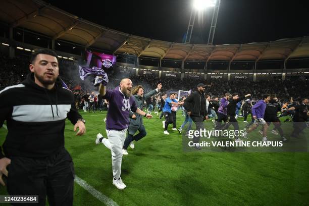 Toulouse's supporters invade the pitch to celebrate their team's victory and promotion back to Ligue 1 after the French L2 football match between...