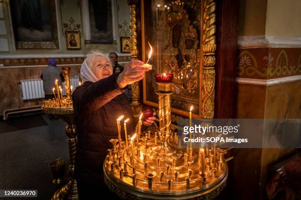 An old lady lighting up candles in an Orthodox Monastery in Kharkiv. Orthodox Easter celebrations come as the Ukraine-Russia war has lasted for two...