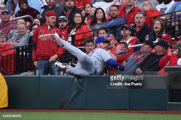 Pete Alonso of the New York Mets falls into the stands while catching a fly ball hit by the St. Louis Cardinals during the first inning at Busch...
