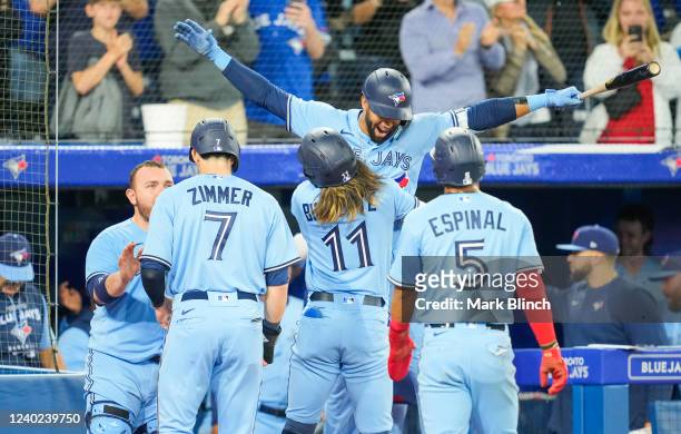 Bo Bichette celebrates his grand slam by hugging Lourdes Gurriel Jr. #13 of the Toronto Blue Jays in the eighth inning of their game against the...