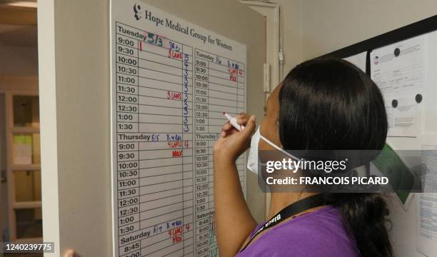 An employee adds codes to a schedule board at the Hope Medical Group for Women in Shreveport, Louisiana, April 19, 2022. - On September 1 one of the...