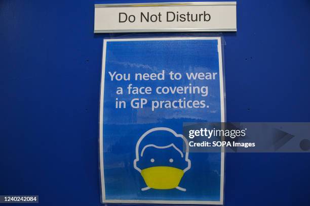 You need to wear a face covering in GP practices.' sign displayed at a doctors surgery.