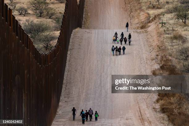 Group of migrant families from Central America walk along side the border wall between the U.S. And Mexico after crossing in to the U.S. Near the...