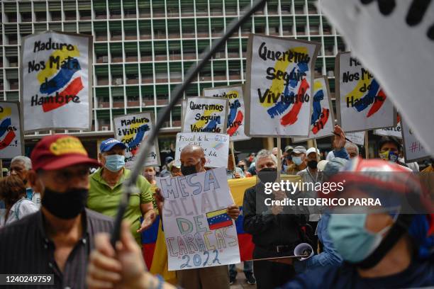 Workers and pensioners take a part in a protest to demand better salaries and pensions, outside the Ministry of Labour in Caracas, on April 26, 2022....