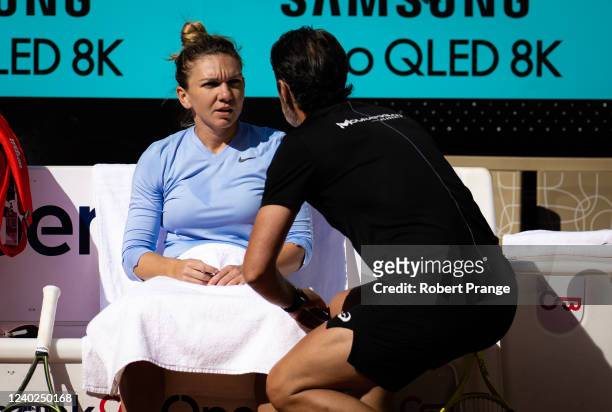 Simona Halep of Romania listens to coach Patrick Mouratoglou during practice ahead of the Mutua Madrid Open at La Caja Magica on April 26, 2022 in...